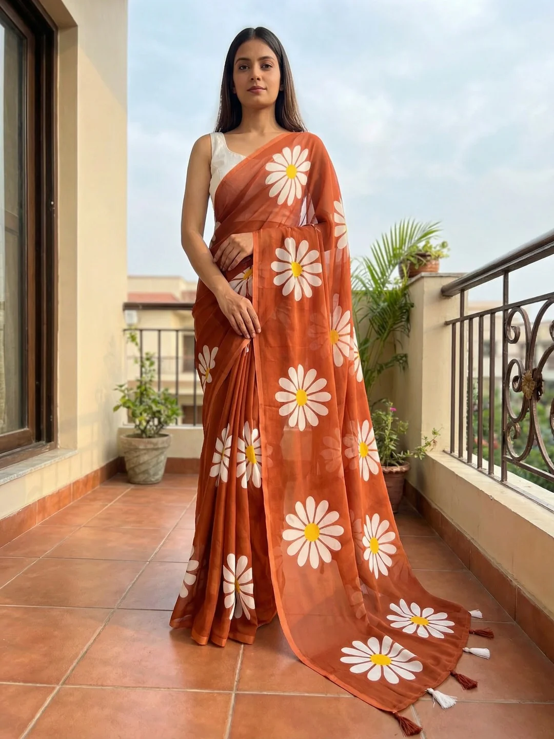 Rust Georgette Saree Featuring Delicate Floral Prints & Tassels Pallu